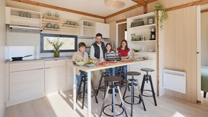 Une cuisine moderne dotée d’un îlot central, de tabourets de bar et d’un coin repas.