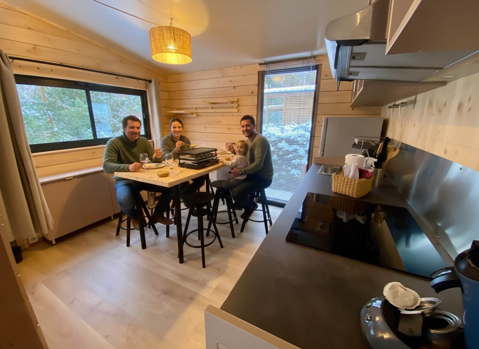 Een gezellige keuken met houten wanden, een eettafel en een moderne kookplaat.