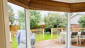 A bay window with a view of a wooden deck and outdoor furniture. - FunKidHouse*NearWEM*FamilyBabyKidFriendly*Kingbed* (Edmonton)