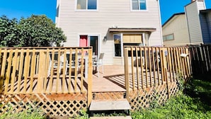 A two-story house with a front deck and a wooden fence. - FunKidHouse*NearWEM*FamilyBabyKidFriendly*Kingbed* (Edmonton)