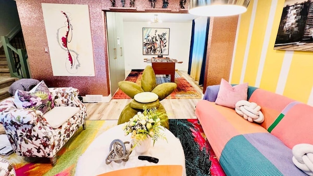 A modern living room with a sofa, a coffee table, and a decorative wall piece. - FunKidHouse*NearWEM*FamilyBabyKidFriendly*Kingbed* (Edmonton)