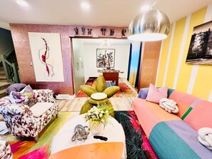 A modern living room with a sofa, a coffee table, and a decorative wall piece.