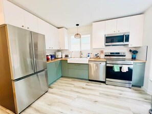 A modern kitchen with stainless steel appliances, a dishwasher, and a microwave.
