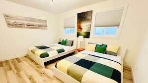 A bedroom with two beds, a nightstand, and a window with blinds. - FunKidHouse*NearWEM*FamilyBabyKidFriendly*Kingbed* (Edmonton)