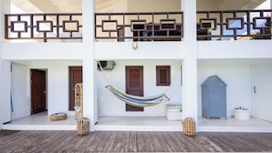 A two-story building with a wooden deck, a hammock, and a pool. - Luxurious 2-Bedroom Apartment in Jan Thiel, Curaçao (Jan Thiel)
