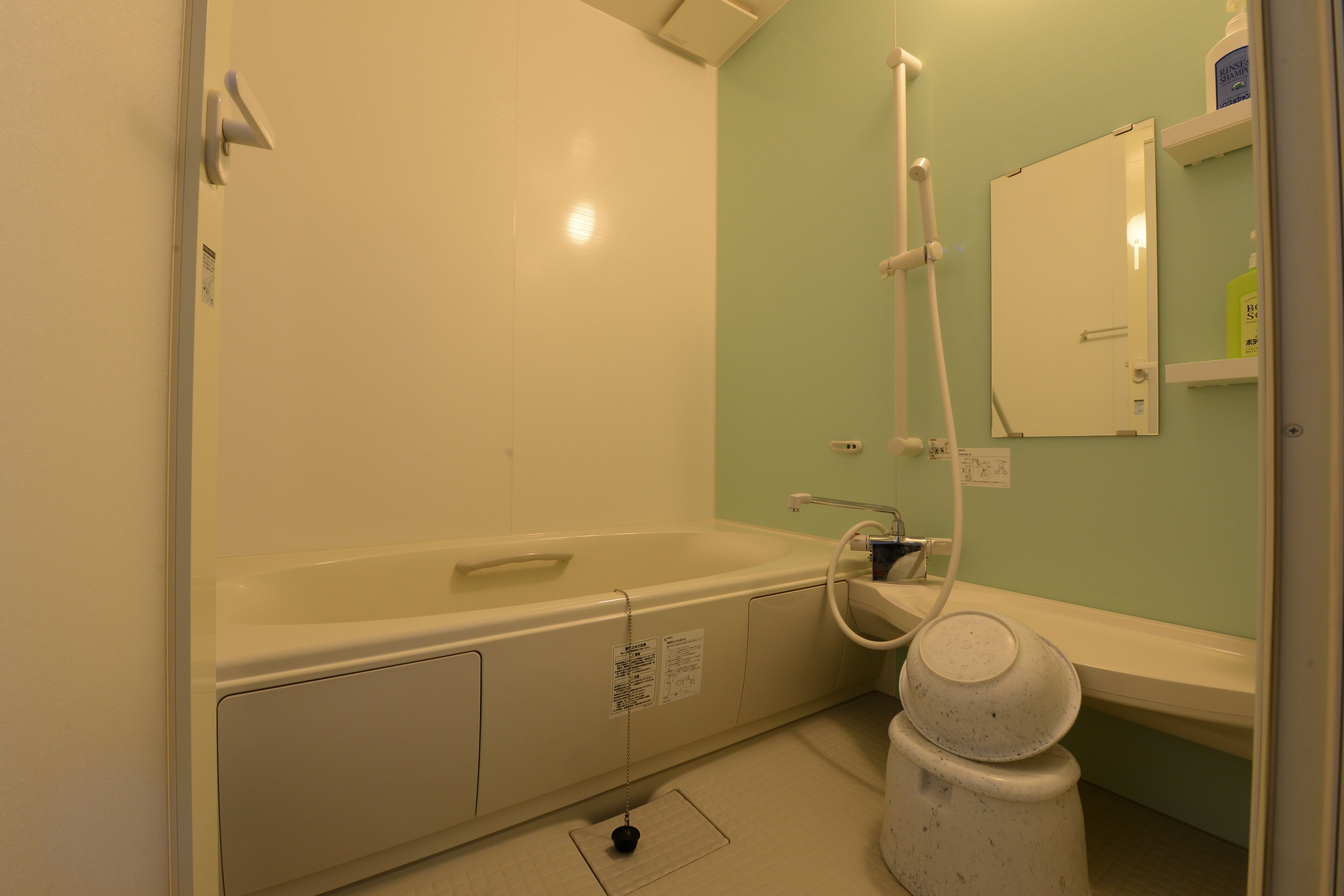 Un baño con bañera, lavamanos, espejo e inodoro.