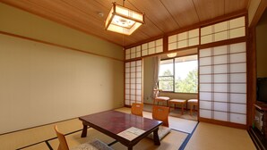 Een traditionele Japanse kamer met tatami vloerbedekking, een lage houten tafel en schuifdeuren van shoji papier.