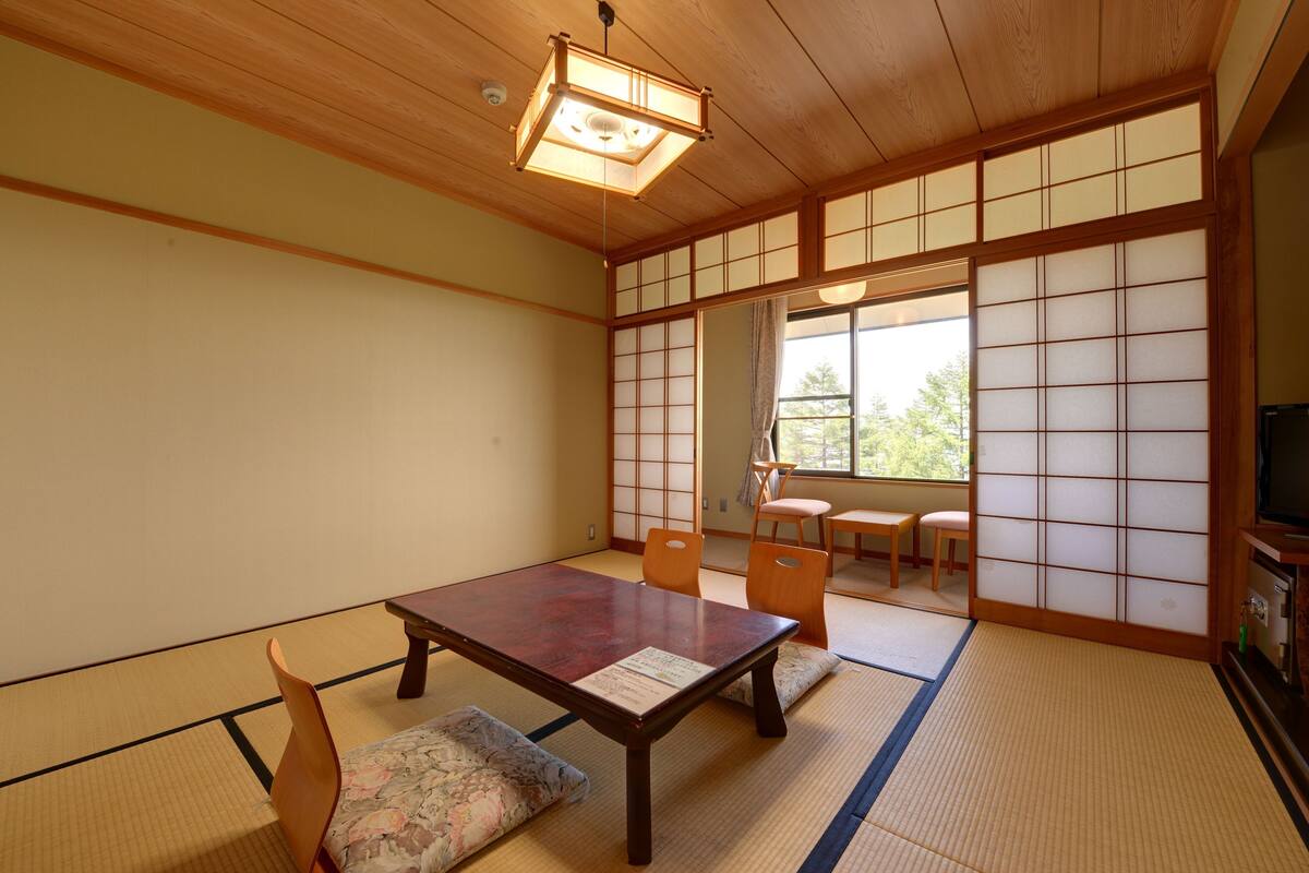 A traditional Japanese room with tatami flooring, a low wooden table, and sliding shoji doors.