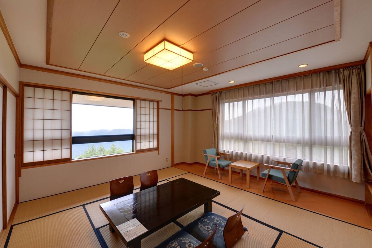 A traditional Japanese-style room with tatami flooring, a low table, and shoji screens.