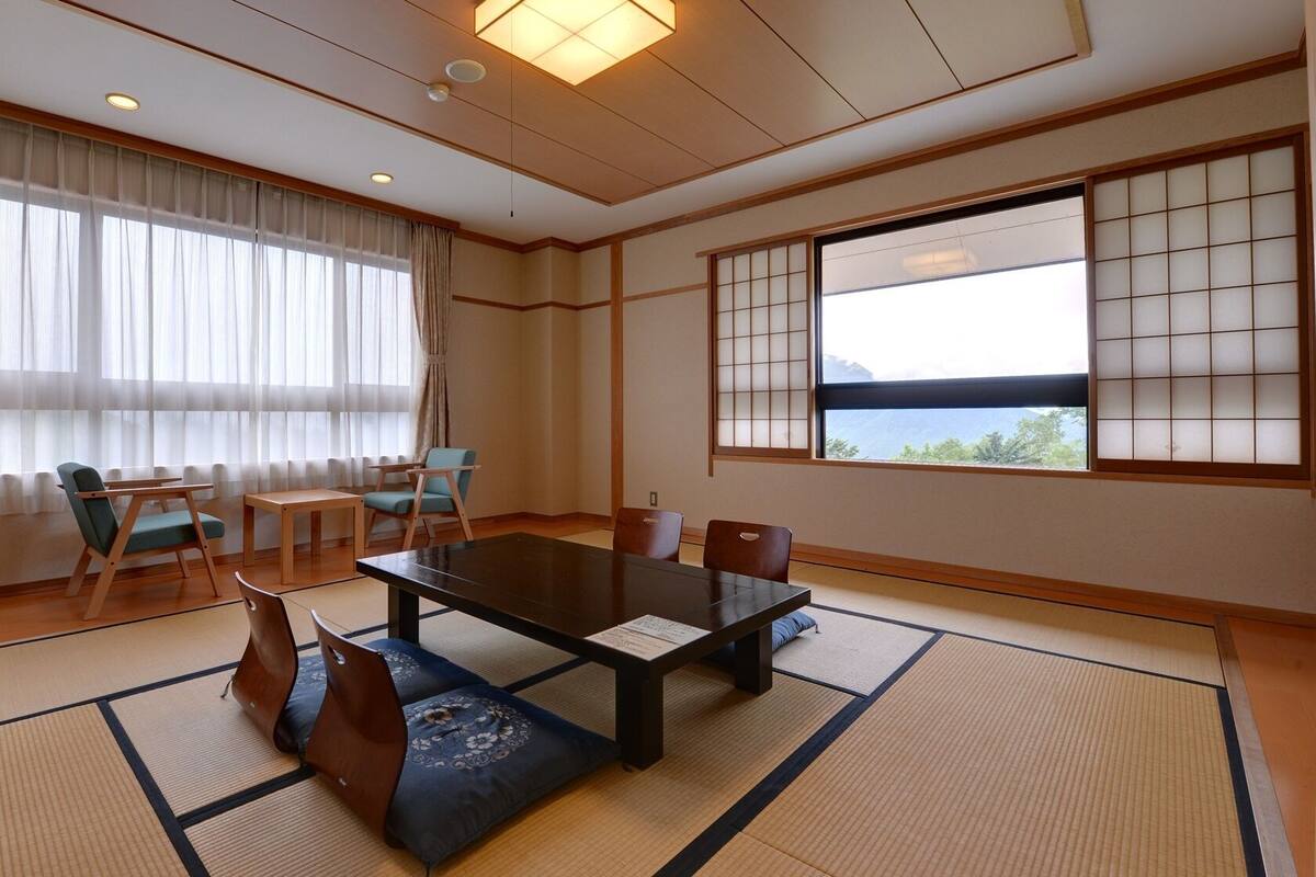 A traditional Japanese room with tatami flooring, a low table, and shoji screens.
