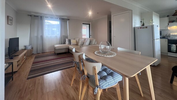 Un espace de vie moderne comprenant un coin repas, une cuisine et un coin salon.