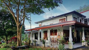 A two-story house with a covered porch, potted plants, and outdoor furniture. - Handiranwila Resort (Anguruwatota)