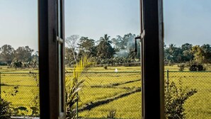 A view through a window of a rural landscape with fields and trees. - Handiranwila Resort (Anguruwatota)