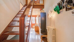 A wooden staircase leading to a second floor, a radiator, and a wall-mounted mirror with a towel. - Slalom 73 few Steps From Skiing (Bardonecchia)
