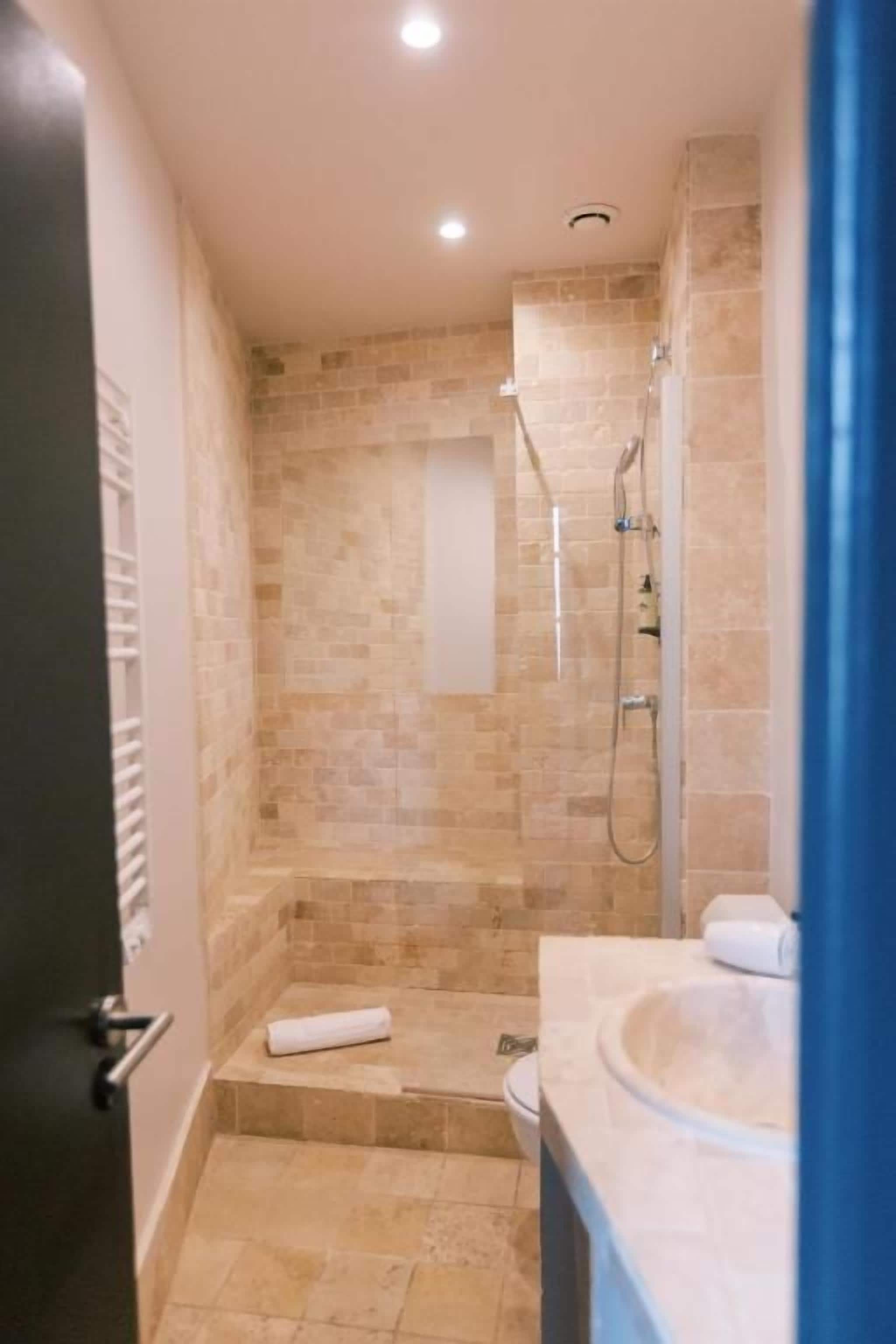 A bathroom with a shower, a toilet, and a sink.