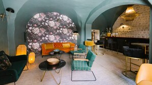 A cozy interior with a sofa, chairs, a round table, and a bar area. - Victoria Boutique Hôtel (Saint-Paul-Trois-Chateaux)