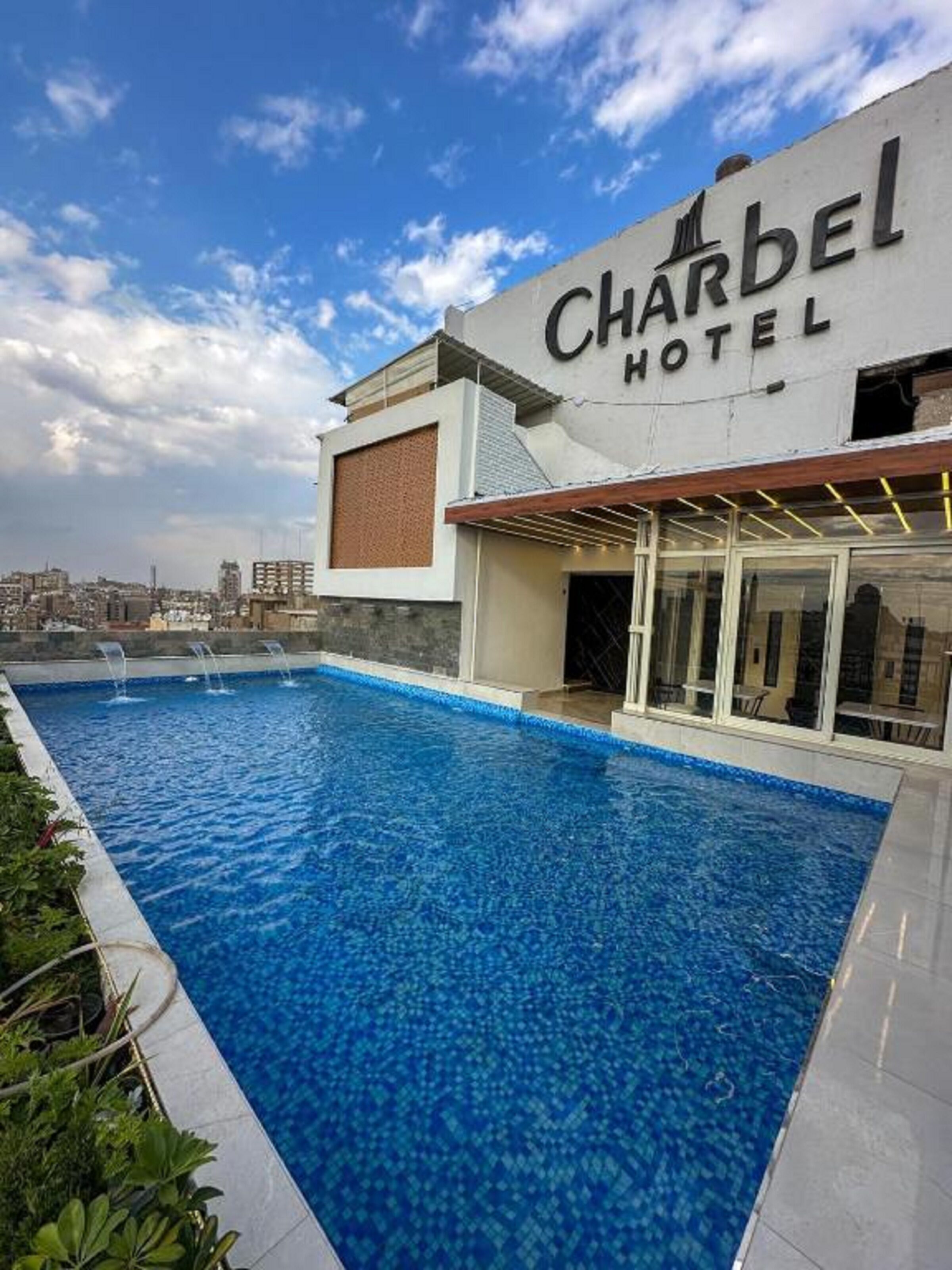 A Charbel Hotel with a swimming pool and a city view.