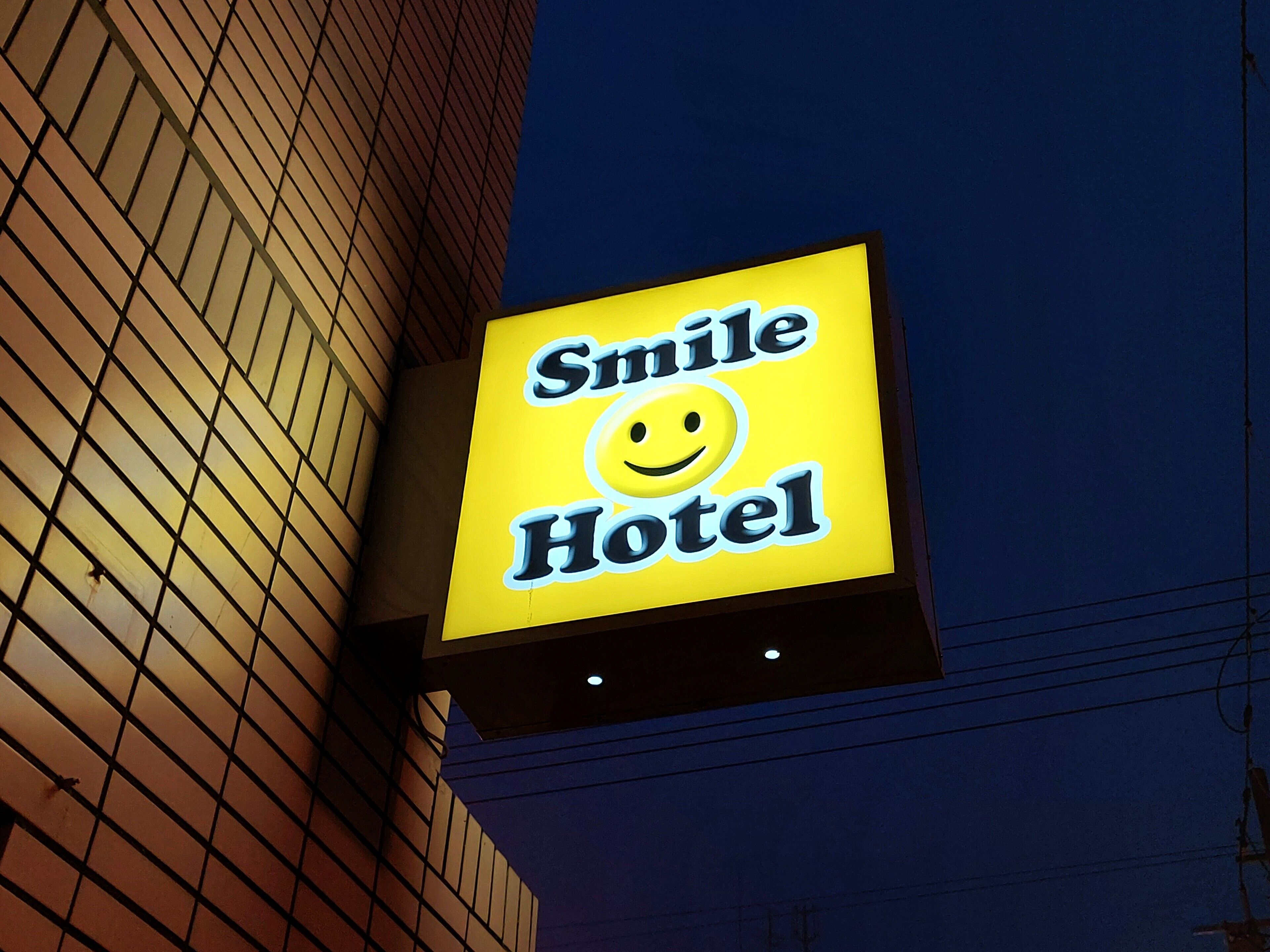 A sign for the Smile Hotel with a smiley face logo.