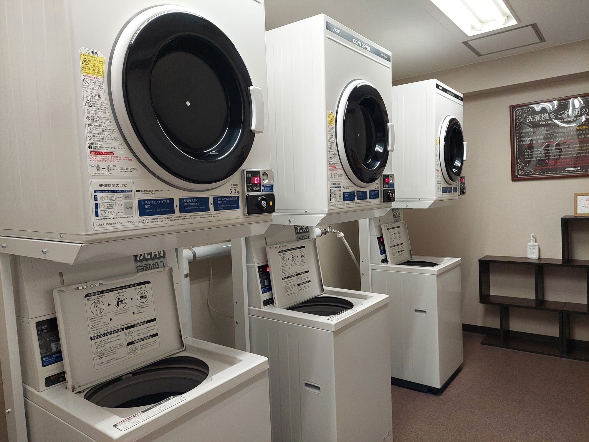 A row of front-loading washing machines in a commercial setting.
