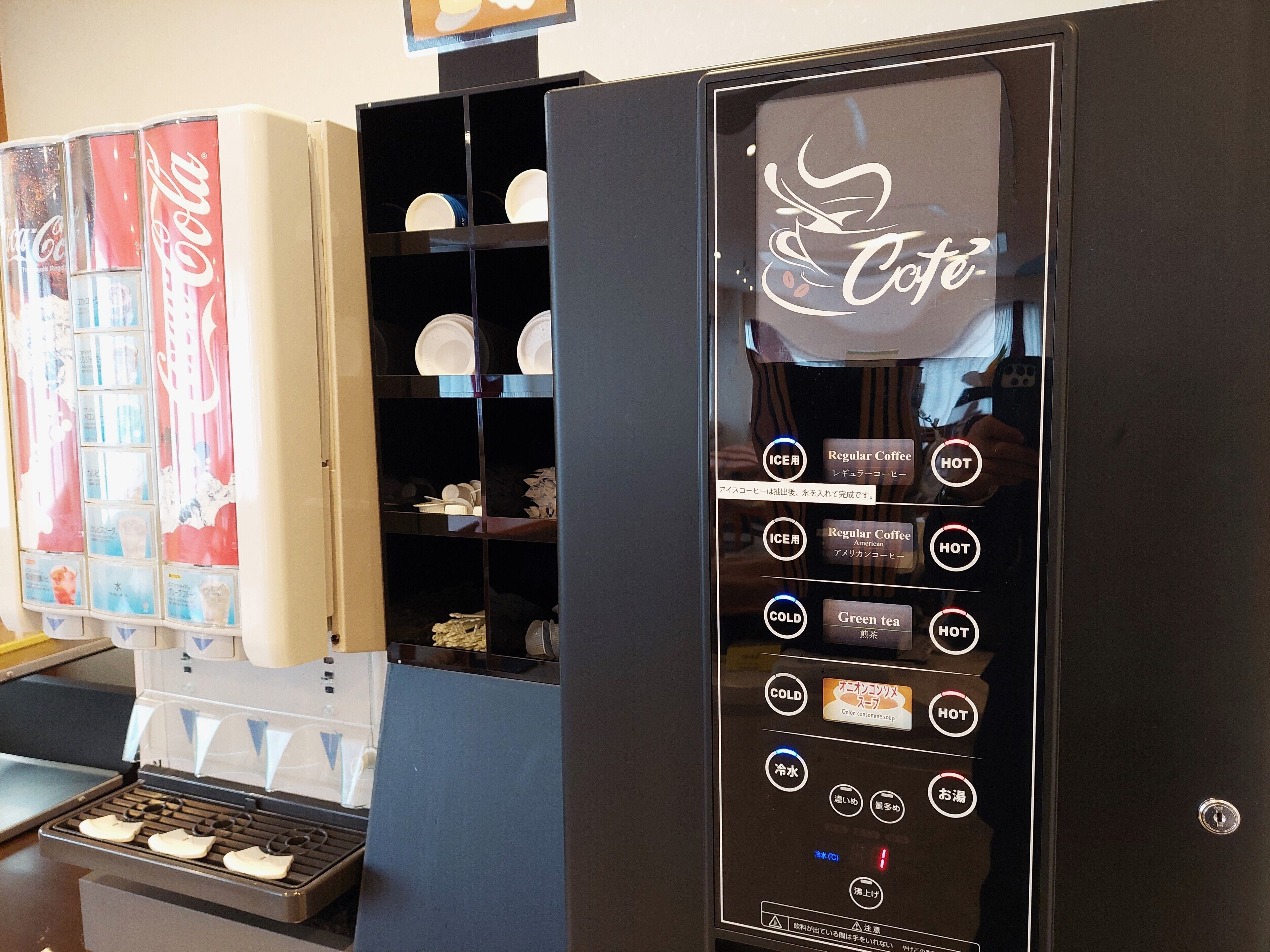 A vending machine with options for regular coffee, hot beverages, and green tea.