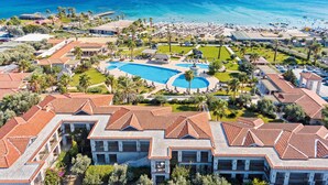 Un resort con una piscina grande, playa y vistas al océano.