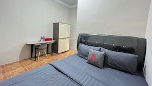 A bedroom with a bed, a desk, and a wardrobe.