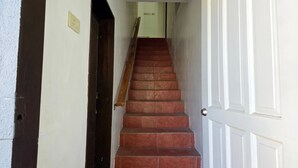 A staircase with red steps leading to a white door. - Surfers Point Deck An'nex (San Juan)