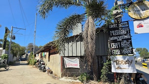 Eine Straße mit Schildern für ein Hostel, ein Pilz-Café und handwerkliches Bier.