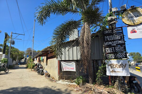 Eine Straße mit Schildern für ein Hostel, ein Pilz-Café und handwerkliches Bier.