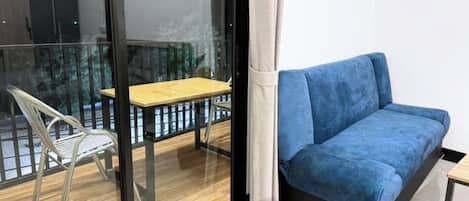 A modern room with a blue sofa, a small wooden table, and a metal chair.