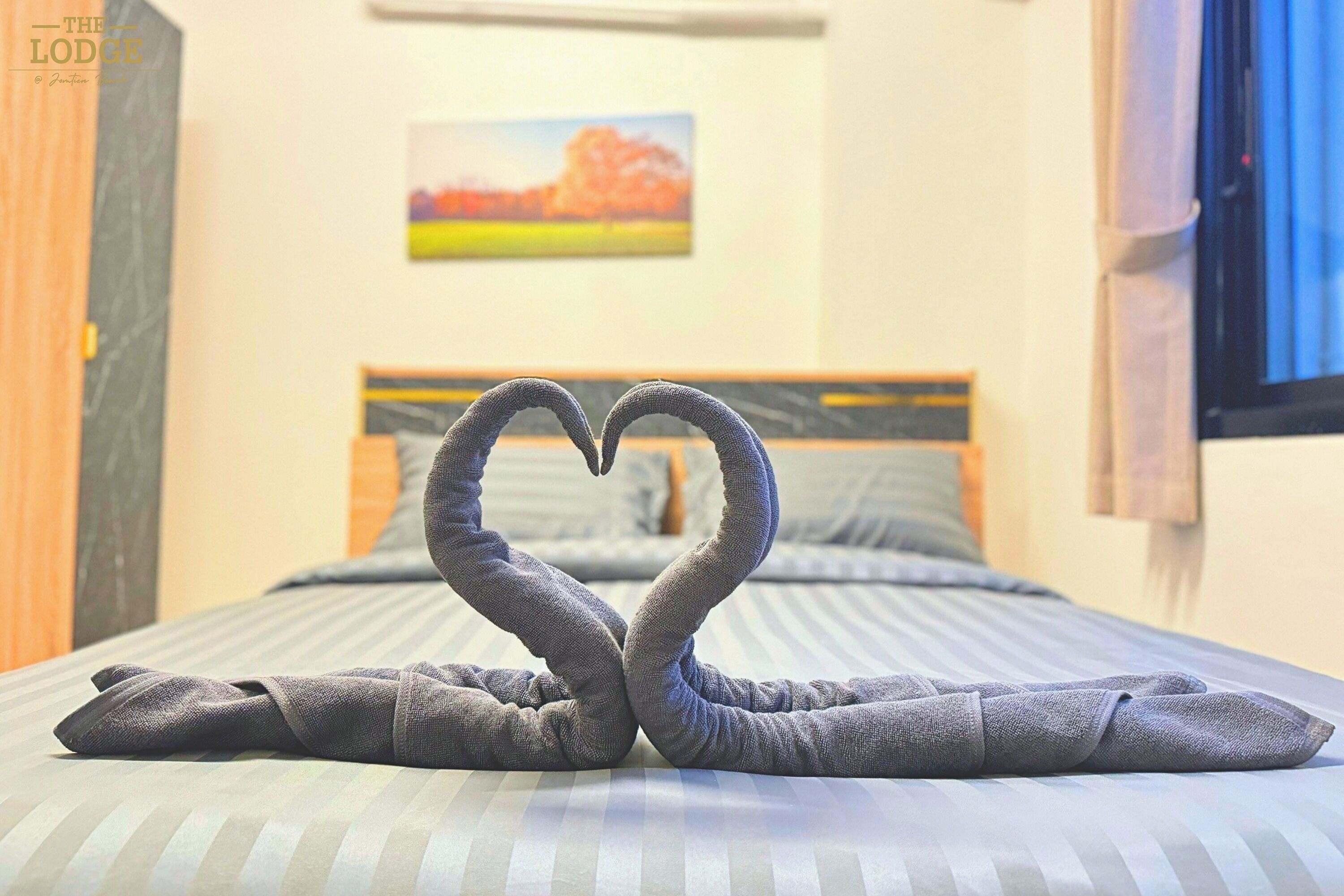 A bed with a heart-shaped towel arrangement.