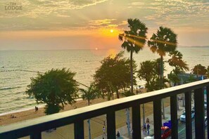 A beach view with palm trees and a sunset. - The Lodge Jomtien 7 (Pattaya)