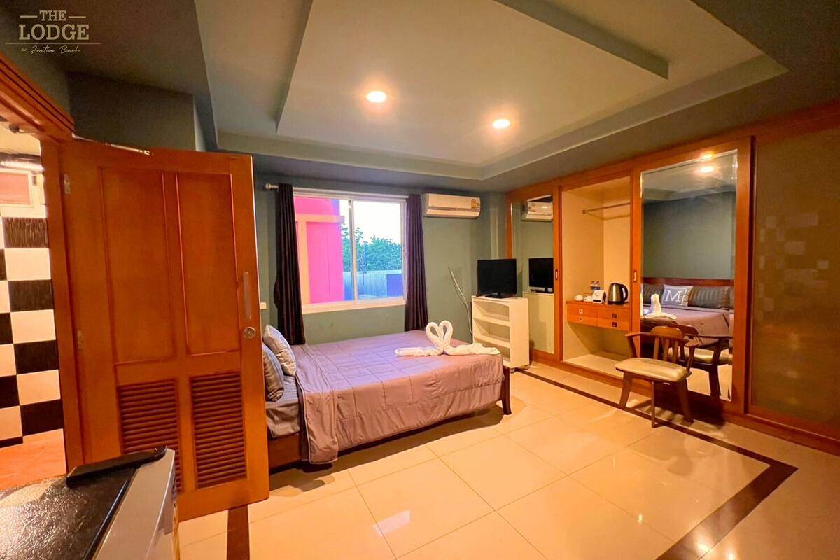 Une chambre à coucher avec un lit, un bureau, une chaise et un téléviseur.