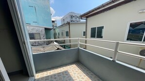 A small, enclosed balcony area with tiled flooring and a metal railing. - Pocket Pillow Patong (Patong)