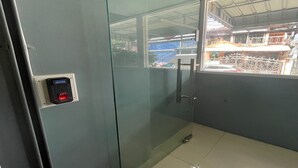 A glass-walled room with a digital lock on the door, a small window, and a metal handle. - Pocket Pillow Patong (Patong)