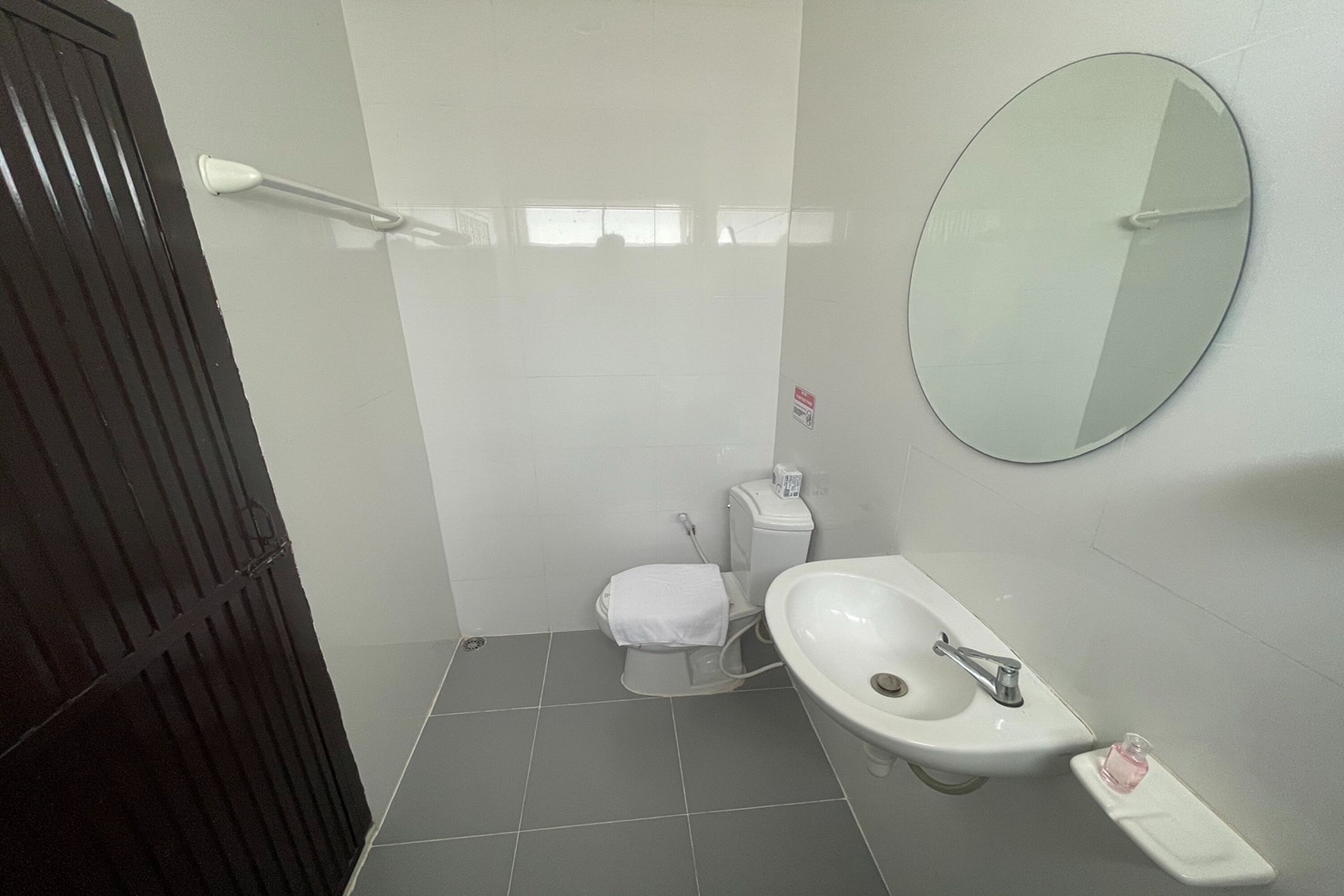 Une salle de bain avec des toilettes, un lavabo et un miroir.