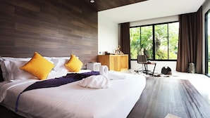 Een moderne hotelkamer met een groot bed, een houten hoofdeinde en uitzicht op groen.