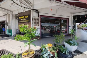 The exterior of Kuang Hua Hotel with a tiled entrance, potted plants, and a visible air conditioning unit. - Hotel Kuang Hua Sitiawan Near To (UniKL-MIMET) (Sitiawan)