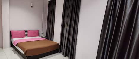 A modern hotel room with a bed, black curtains, and a white tiled floor.
