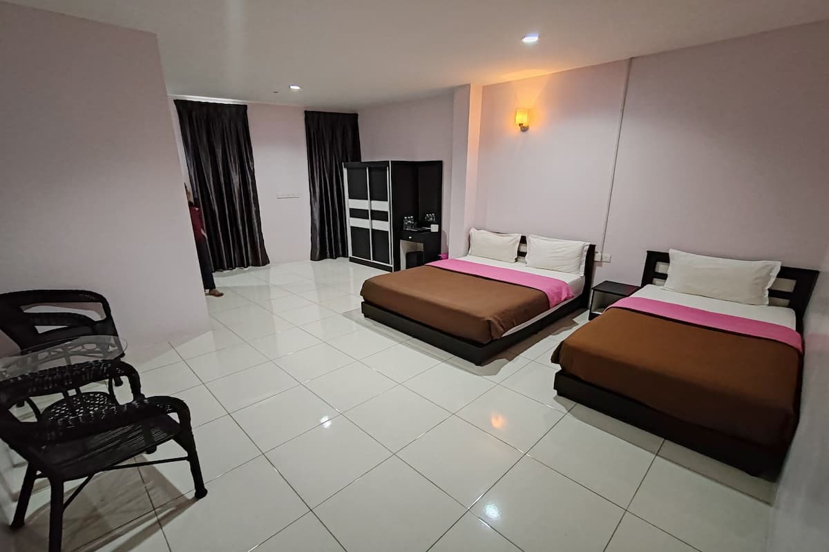 A hotel room with two beds, a desk, a chair, and a wardrobe.