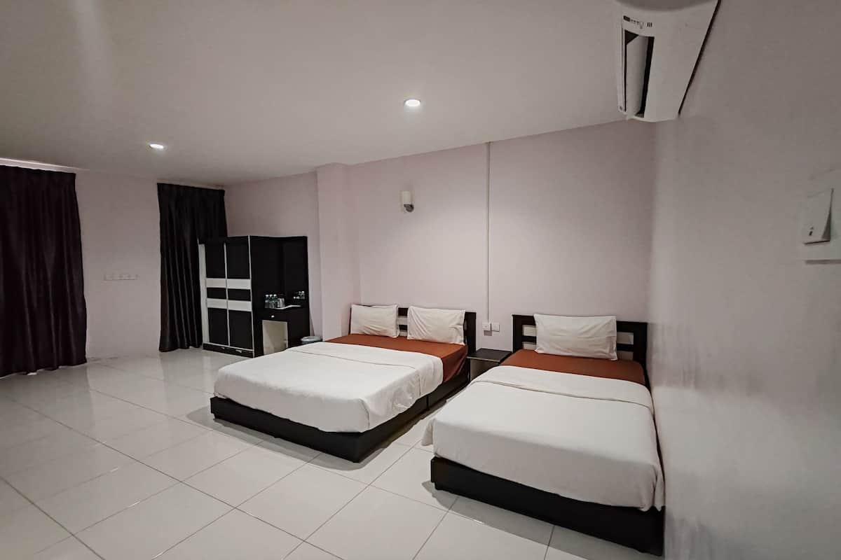 A hotel room with two beds, a wardrobe, and a mirror.
