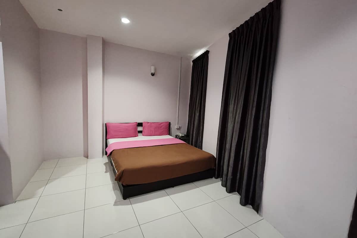 A bedroom with a bed, white tiled floor, and dark curtains.