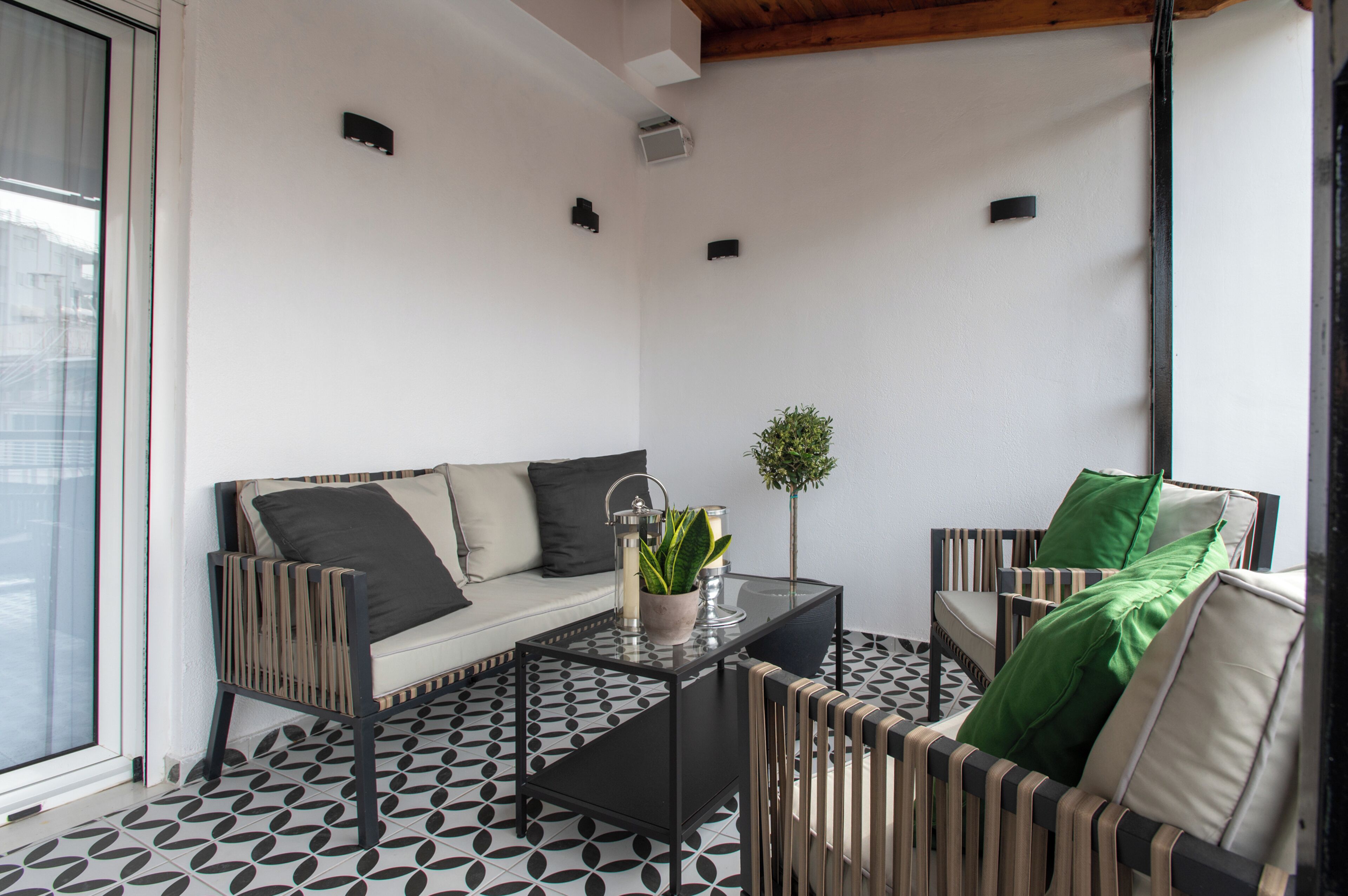 Un salon moderne avec un canapé, des fauteuils, une table basse et une plante en pot.