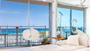 Ein modernes Wohnzimmer mit einem großen Fenster mit Blick auf eine Marina und das Meer.