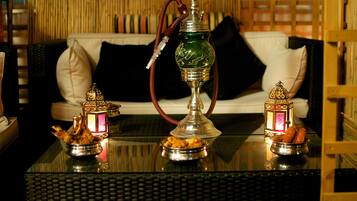 A hookah on a glass table with a sofa in the background.