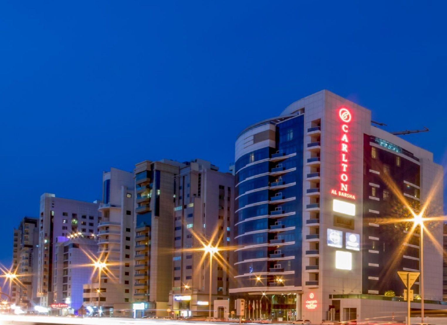 Ett hotell med flera våningar, utmärkt av en tydlig skylt med texten ”Carlton”, vilket visar att det är ett hotell.