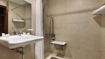 A bathroom with a shower, a sink, and a towel rack.