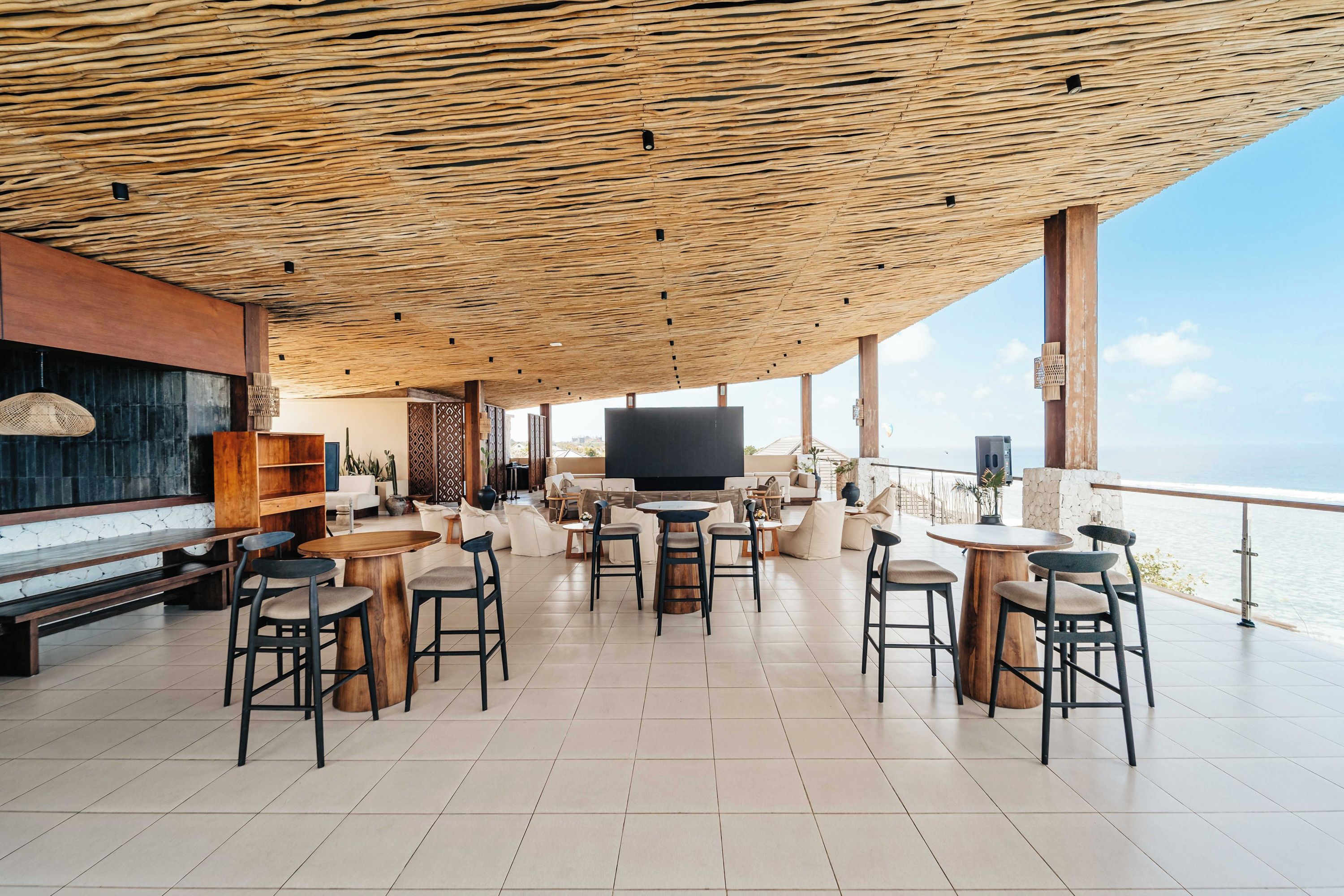 Ein großzügiger Außenbereich mit Lounge-Möbeln, Holzboden und einem großen Flachbildfernseher.