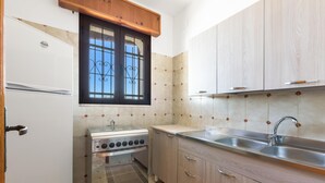 A compact kitchen with a built-in oven, a sink, and wooden cabinets. - 3824 Sabbiabianca - Aptm A by Barbarhouse (Porto Cesareo)