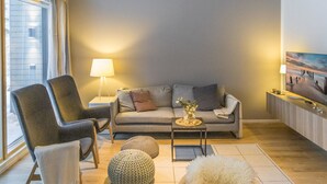A modern living room with a grey sofa, a black armchair, a small coffee table, and a lamp.
